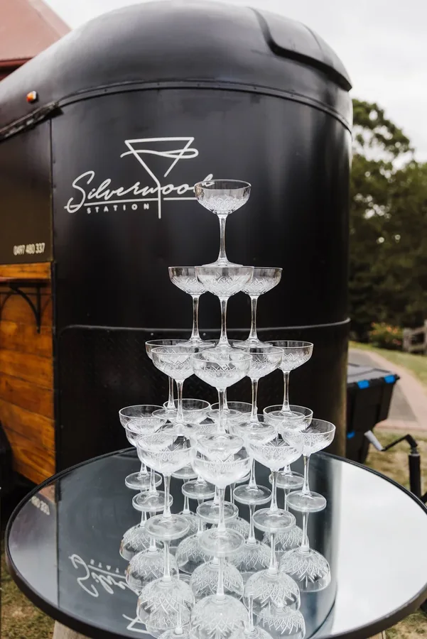 Four-tier champagne tower of coupe glasses in front of the Silverwood Station float